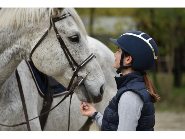 Allieva accanto a un cavallo grigio al centro ippico